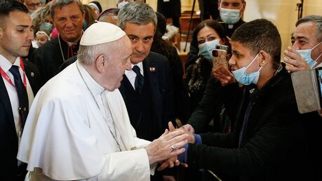 Papst Franziskus hält die Hand eines jungen Mannes / © Paul Haring (KNA)