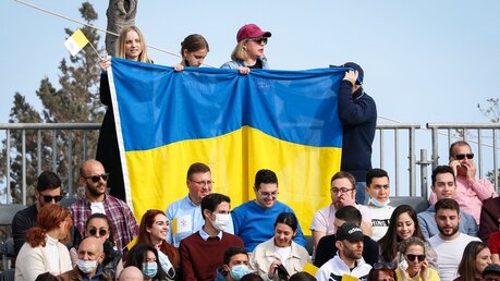 Menschen halten eine ukrainische Nationalflagge bei einer Messe mit Papst Franziskus in Floriana (Malta) / © Paul Haring (KNA)