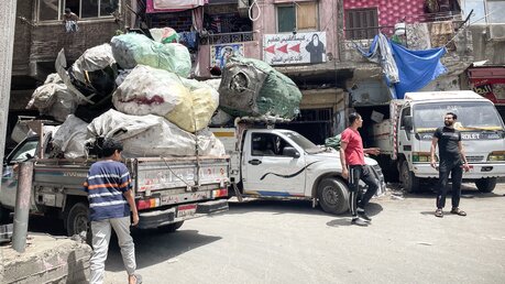 Die LKWs mit Müllsäcken gehören zum Straßenbild in dem Armenviertel Kairos. / © Manuel Meyer (KNA)