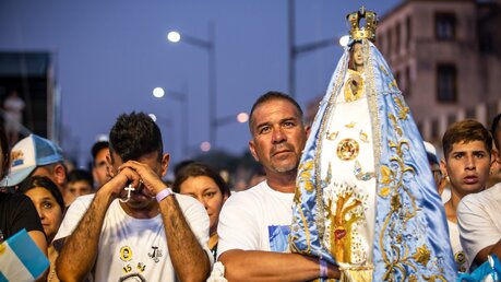 Ein Mann hält während der Prozession die Heiligenfigur der Nuestra Senora de Lujan (Jungfrau von Lujan). / © Mariano Campetella (KNA)