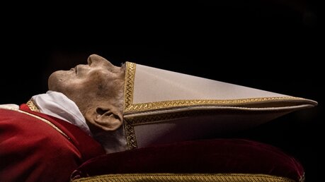 Der verstorbene emeritierte Papst Benedikt XVI. wird im Petersdom aufgebahrt. Manche Menschen finden diese Bilder pietätlos. Jedoch gibt es auch Lob für diese Art des Abschiednehmens / © Oliver Weiken (dpa)