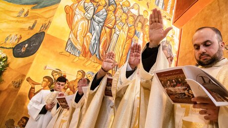 Während der Eucharistiefeier erheben Priester die Hand bei der Priesterweihe in der Kirche des Guten Hirten am 12. Januar 2023 in Amman, Jordanien. / © Andrea Krogmann (KNA)