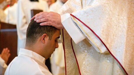 Erzbischof Pierbattista Pizzaballa, Lateinischer Patriarch von Jerusalem, legt die Hände auf den Kopf des Priesteramtskandidaten Yazan Fareed Bader bei seiner Priesterweihe. / © Andrea Krogmann (KNA)