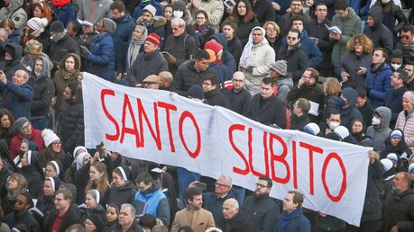 Teilnehmer des Trauergottesdienstes halten ein großes Banner mit der Aufschrift in roten Lettern "Santo Subito" (dt. rasche Selig- und Heiligsprechung). / © Chris Warde-Jones/CNS photo (KNA)