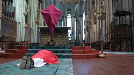 Die so genannte Prostatio: Kardinal Woelki wirft sich am Karfreitag als Zeichen der Demut vor dem verhüllten Kreuz nieder / © Henning Schoon (Kirchenzeitung Koeln)