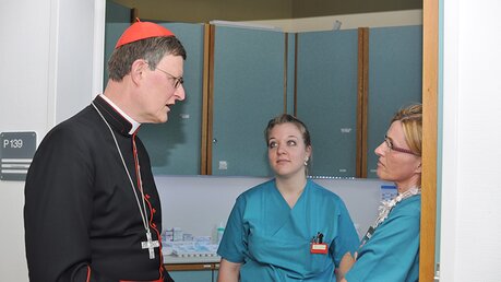 Kardinal Woelki bei einem Besuch 2015 im Gespräch mit Pflegerinnen des Bensberger Hospizes. / © Beatrice Tomasetti (DR)