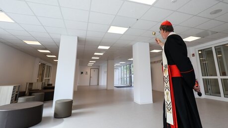 Kardinal Woelki segnet das Foyer der neuen Grundschule in Köln-Kalk mit Weihwasser.  / © Schoon (Erzbistum Köln)