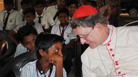 Kardinal Woelki unterhält sich mit einem Jungen in der Bildungseinrichtung Center of Excellence / © Nadim Ammann (Erzbistum Köln)