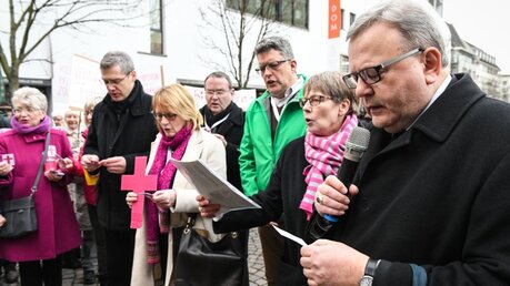 Mitglieder der Synodalversammlung singen beim Einzug in den Frankfurter Dom mit Demonstranten / © Harald Oppitz (KNA)