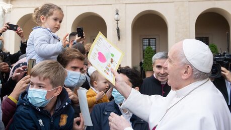 Papst Franziskus nimmt eine Kinderzeichnung entgegen bei der Generalaudienz am 19. Mai 2021 / © Vatican Media/Romano Siciliani (KNA)