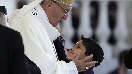 Franziskus umarmt einen Jungen während der Heiligen Messe in Fatima. / ©  Alessandra Tarantino (dpa)