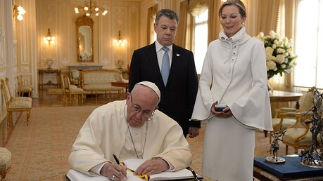 Der Papst in Kolumbien: Franziskus unterschreibt im Gästebuch von Präsident Santos / © Claudia Contreras (dpa)