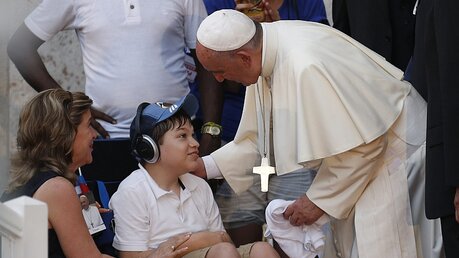 Franziskus begrüßt Kind im Rollstuhl / © Orlando Barria (dpa)
