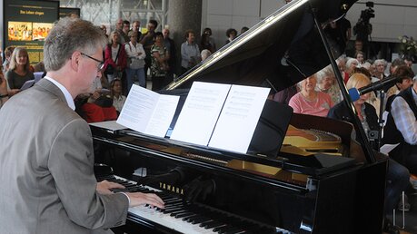Regionalkantor Christoph Kuhlmann begleitet Lieder aus der "Mundorgel" am Flügel. / © Tomasetti (DR)