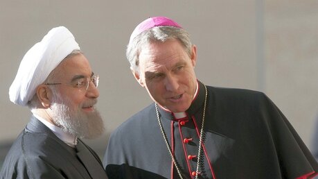 Kurienerzbischof Gänswein im Gespräch mit Präsident Ruhani (l) / © Andrew Medichini (dpa)