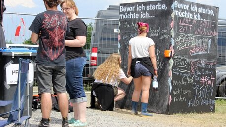 "Bevor ich sterbe, möchte ich..." Jugendliche schreiben Gedanken an eine Tafel. / © Moritz Dege (DR)