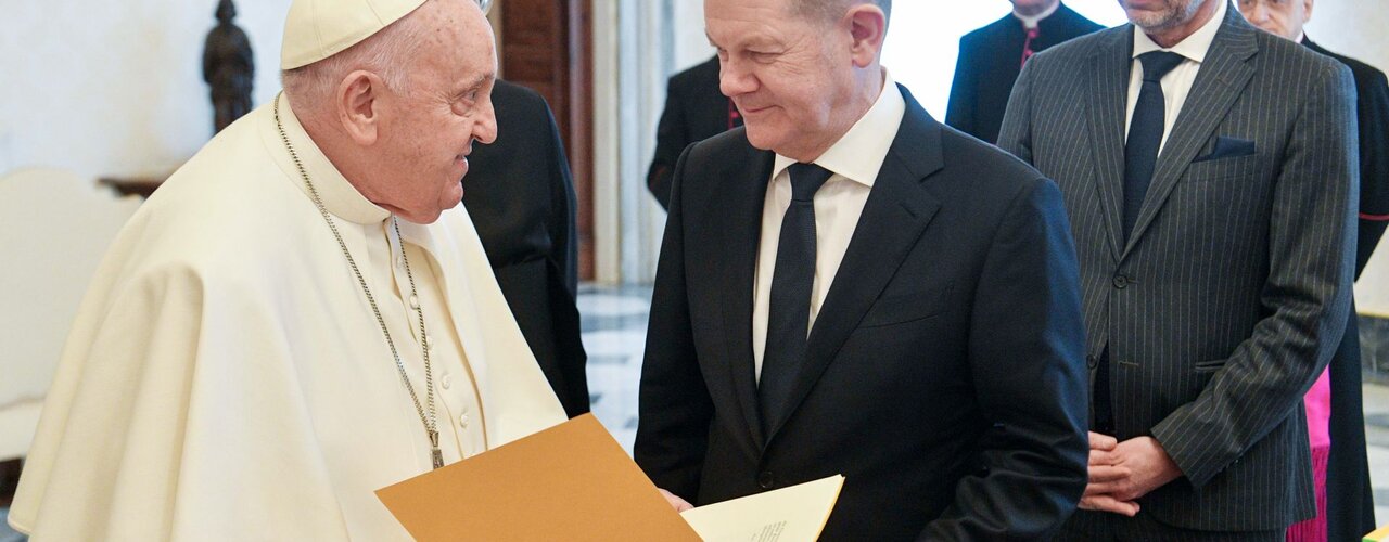 Der Papst übergibt Scholz Bände der päpstlichen Dokumente und diesjährigen Botschaft für den Frieden / © --/Vatican Media (dpa)