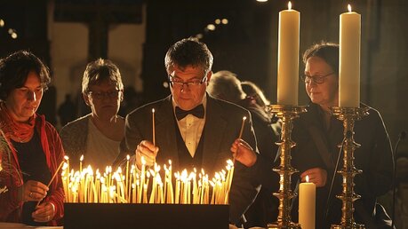 Der Landesbischof der Evangelischen Kirche in Mitteldeutschland (EKM), Friedrich Kramer, zündet nach dem Gottesdienst in der Kirche eine Kerze an / © Steffen Schellhorn (epd)