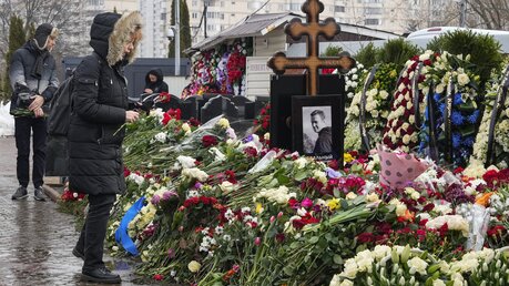Eine Frau legt einen Tag nach der Beerdigung von Alexej Nawalny auf dem Borisowskoje-Friedhof Blumen am Grab ab. Nawalny, der der schärfste Gegner von Präsident Wladimir Putin war, wurde nach einer Beerdigung, an der Tausende von Trauernden teilnahmen, unter starker Polizeipräsenz beigesetzt. / © Uncredited/AP (dpa)