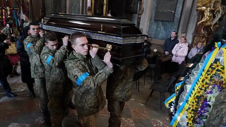 Ukrainische Soldaten tragen, während einer Trauerfeier in der Kirche der heiligen Apostel Peter und Paul in Lwiw, den Sarg eines ukrainischen Kameraden. / © Bryan Smith/ZUMA Press Wire (dpa)