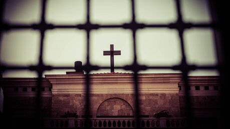 Kreuz hinter Gitterstäben / © Jeremiah Castelo (shutterstock)