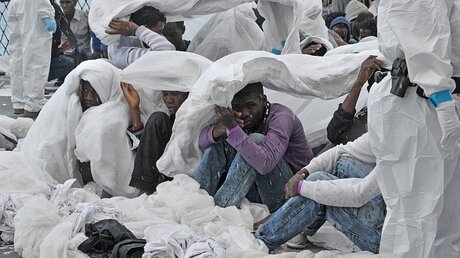 Flüchtlinge schützen sich mit Decken vor Regen / © Gioia Forster (dpa)