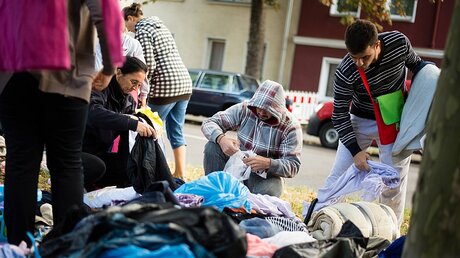 Flüchtlinge mit gespendeter Kleidung / © Gregor Fischer (dpa)