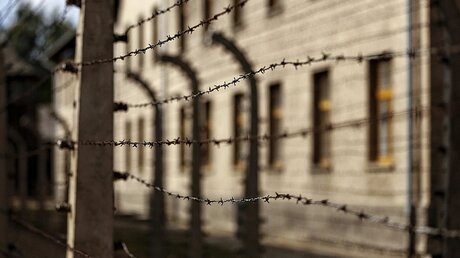 Stacheldrahtzaun vor den Gebäuden des ehemaligen Konzentrationslagers und der heutigen Gedenkstätte Auschwitz-Birkenau  / © Nancy Wiechec (KNA)