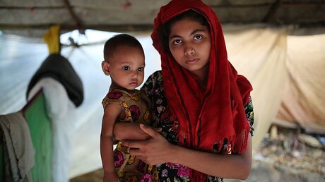 Eine junge Rohingya mit ihrem Kind / © Zakir Hossain Chowdhury (dpa)