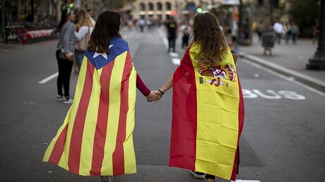 Zwei junge Frauen mit spanischer Nationalflagge (r.) und katalanischer Flagge / © Emilio Morenatti (dpa)