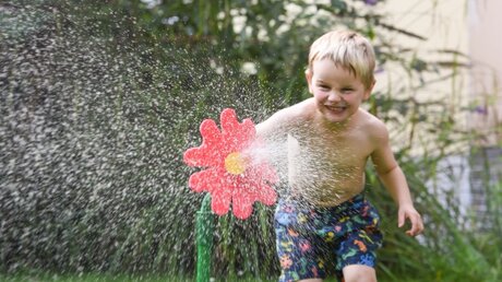 Abkühlung: Ein Junge spielt mit Wasser  / © Harald Oppitz (KNA)