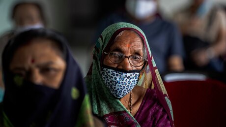 Ältere indische Frauen und Männer warten auf ihre Corona-Impfung / © Anupam Nath (dpa)