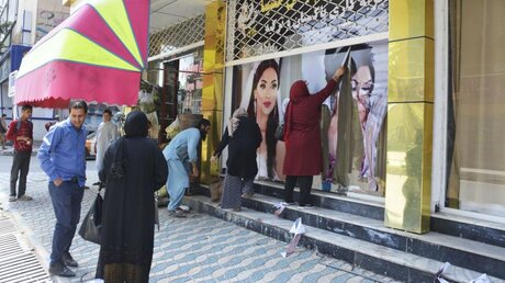Afghanistan, Kabul: Arbeiter in einem Schönheitssalon entfernen große Fotos von Frauen von der Wand / © Kyodo (dpa)
