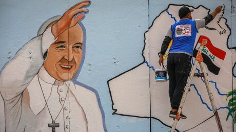 Amjad, ein irakischer Künstler der NGO "Imprint of Hope", malt ein Wandbild von Papst Franziskus / © Ameer Al Mohammedaw (dpa)