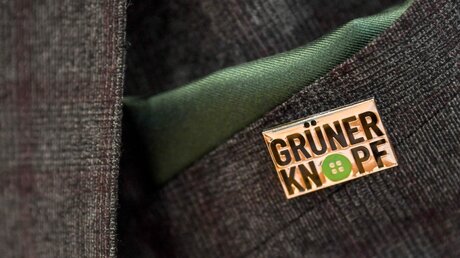 Anstecker mit dem Symbol des staatlichen Textilsiegel "Grüner Knopf" / © Britta Pedersen (dpa)