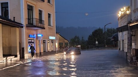 Berchtesgaden: Nach starkem Regen steht Wasser in einer Straße. / © Kilian Pfeiffer (dpa)
