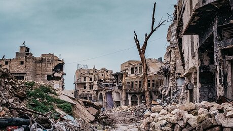 Berge von Steinen liegen zwischen den Ruinen zerbombter Häuser am 16. Dezember 2018 in Aleppo (Syrien). / © Jean-Matthieu Gautier (KNA)