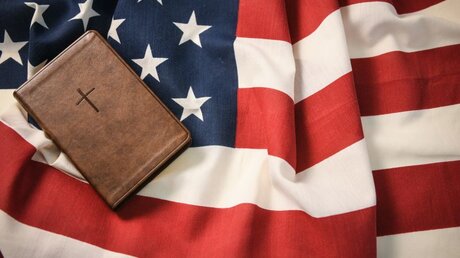 Bibel und US-Flagge / © Julia Steinbrecht (KNA)