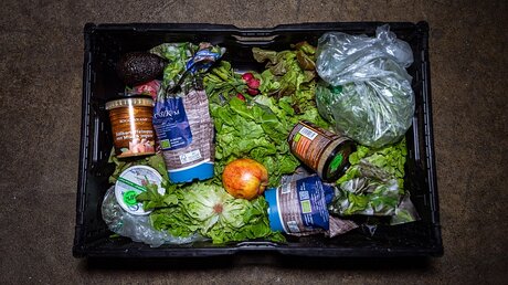 Blick auf eine Kiste mit Nahrungsmitteln / © Mohssen Assanimoghaddam (dpa)