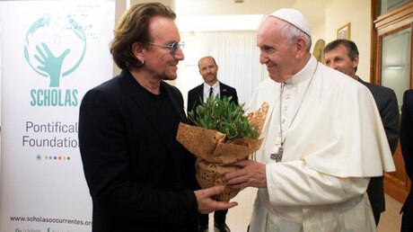  Bono (l), U2-Frontmann, schenkt Papst Franziskus (r) eine Pflanze nach einer Privataudienz / © Especial (dpa)