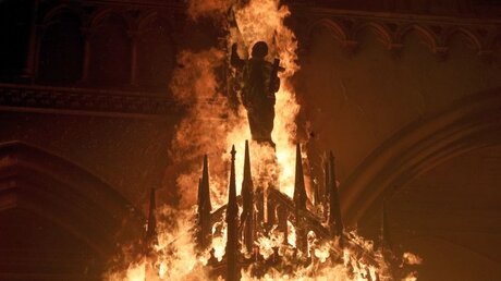 Chile, Santiago: Eine Heiligenfigur brennt, nachdem Demonstranten die Kirche San Francisco de Borja angezündet haben. / © Esteban Felix/AP (dpa)