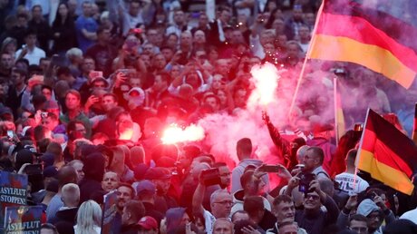  Demonstranten der rechten Szene zünden Pyrotechnik und schwenken Deutschlandfahnen / © Jan Woitas (dpa)