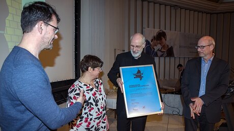 Weihbischof Puff übergibt die Urkunde des "Anerkennungspreis der Jury" an die Redaktion des "Kirchenlatein“ Düsseldorf. / © Marcus Laufenberg (Erzbistum Köln)