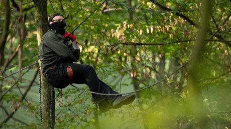 Ein Aktivist hängt im Hambacher Forst an Seilen zwischen den Bäumen / © Marius Becker (dpa)