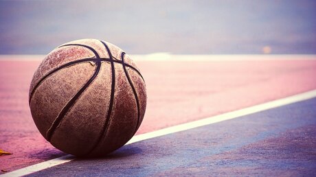 Ein alter Basketball auf einem Sportplatz / © NWStock (shutterstock)