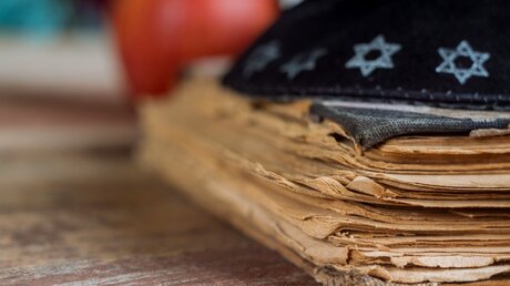Ein altes jüdisches Gebetsbuch und eine Kippa / © Ungvar (shutterstock)