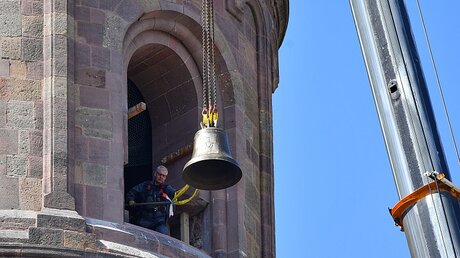 Ein Autokran hebt eine neue Domglocke in den nördlichen Ostturm des Wormser Doms. / © Uwe Anspach (dpa)