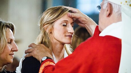 Ein Bischof firmt eine junge Frau / © Guillaume Poli (KNA)