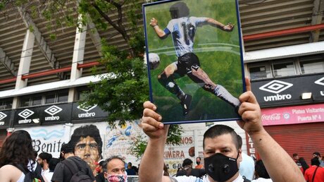 Ein Fan mit argentinischem Trikot hält ein Bild von Diego Maradona hoch / © Alfredo Luna (dpa)