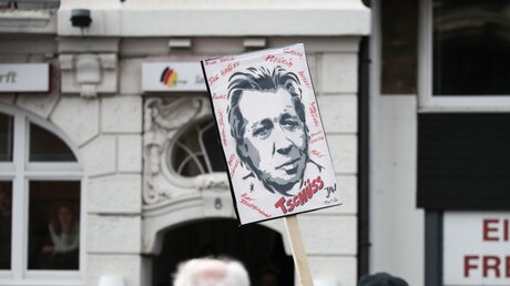 Ein Fan von Jan Fedder hält vor der Trauerfeier für den Schauspieler ein Plakat hoch / © Christian Charisius (dpa)